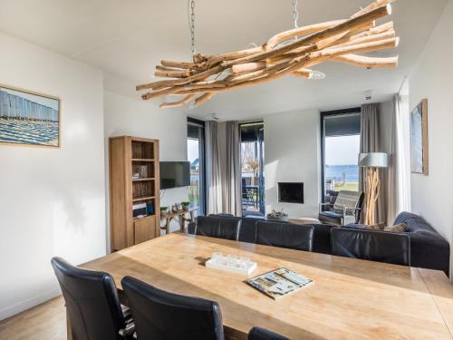 a dining room and living room with a table and chairs at Holiday Home Oesterdam Resort-1 by Interhome in Tholen