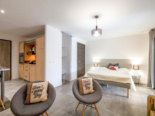 une chambre avec un lit et deux chaises dans l'établissement Apartment Bastion-2 by Interhome, à Porto-Vecchio