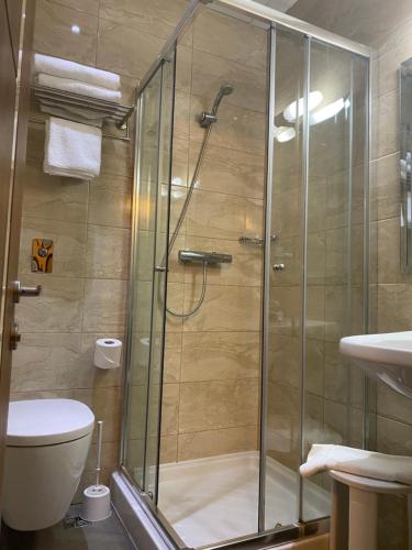 a bathroom with a shower with a toilet and a sink at Grand Harbour Hotel in Valletta