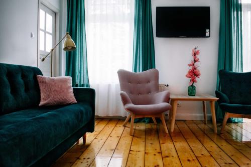 a living room with two green couches and a table at Staszica16 in Złoty Stok