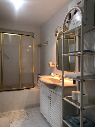 een badkamer met een wastafel, een douche en een spiegel bij apartamento con vista al mar in Benalmádena