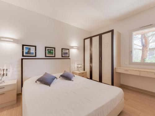 une chambre avec un grand lit blanc avec deux oreillers dans l'établissement Apartment Cala Sultana-3 by Interhome, à Usciolo
