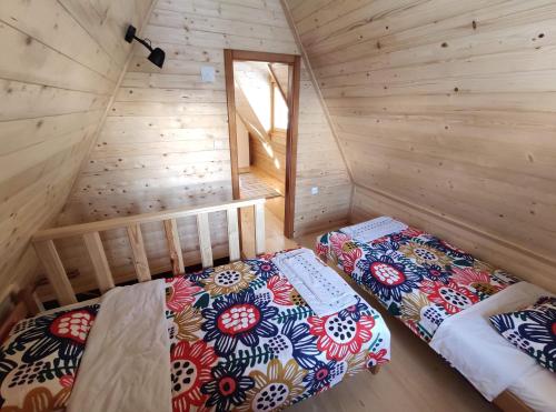 a bedroom with two beds in a wooden cabin at Brvnara 23 minimum 2 noći in Kaludjerske Bare