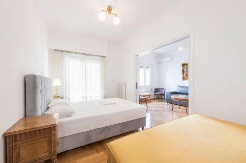 ein Schlafzimmer mit einem Bett und ein Wohnzimmer in der Unterkunft Victoria Supreme Suite in Athen