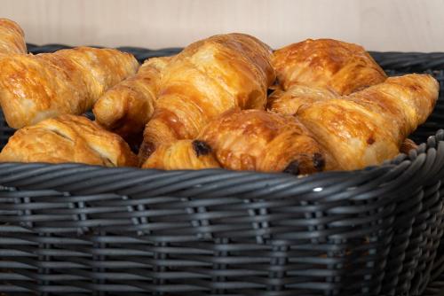 a basket filled with croissants and other pastries at Holiday Inn - the niu, Sparrow Regensburg by IHG in Regensburg