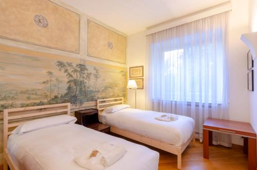 Habitación de hotel con 2 camas y ventana en ALTIDO Apt for 4 with Exclusive Pool and Garden in Nervi en Génova