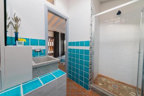 y baño con azulejos azules y blancos y ducha. en Appartamento Giulio, en Villamagna