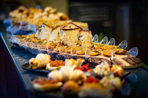 a table topped with different types of food on plates at Tuscany Inn in Montecatini Terme