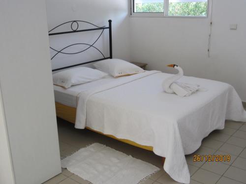 a bedroom with a white bed with a swan on it at BALAGA ocarina in Sainte-Anne