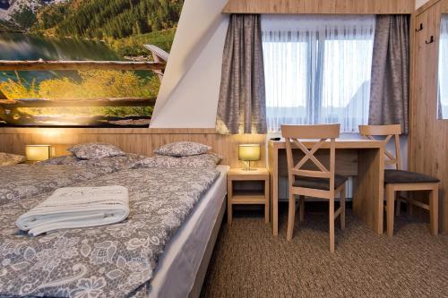 a bedroom with a bed and a desk and a table at Pokoje Gościnne Kornelia- Jacuzzi, sauna ! in Biały Dunajec
