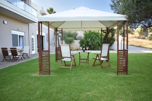 a gazebo with chairs and a table in the grass at Modi Home in Vrísai