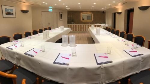 a long table with white tables and chairs in a room at Hotel ARTE Schwerin in Schwerin