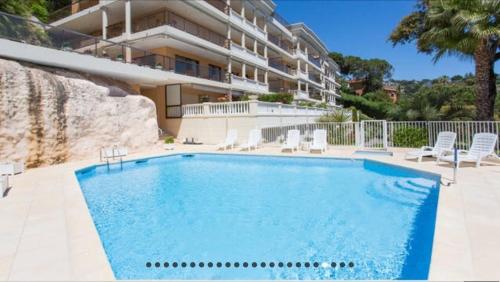 une piscine devant un immeuble dans l'établissement Cozy studio with sea view, swimming pool and greenery, à Cannes