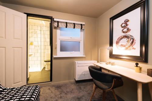 a bathroom with a desk and a bed and a window at The Warwick By Aura Collection in London
