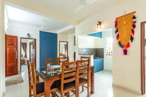 a dining room with blue walls and a table and chairs at Poetrie Homestay in Ernakulam