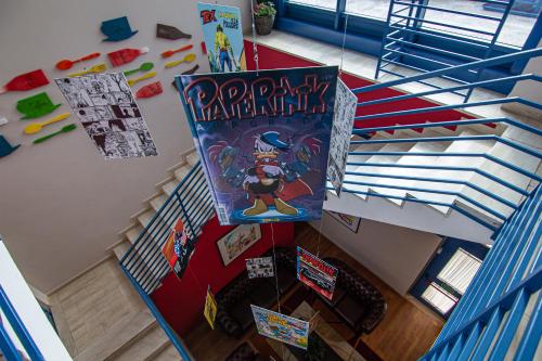 an overhead view of a spiral staircase with a play mario kart poster at Tuscany Inn in Montecatini Terme