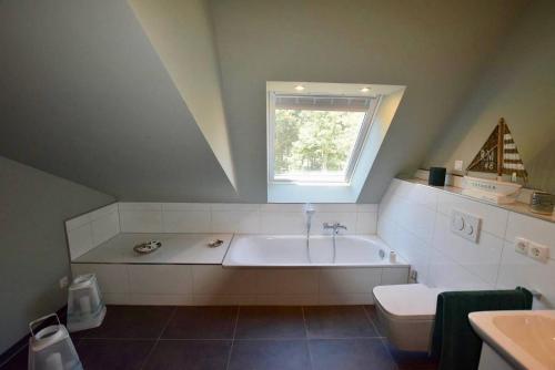 a bathroom with a tub and a toilet and a window at Fewo Seesucht-Hohwacht in Hohwacht