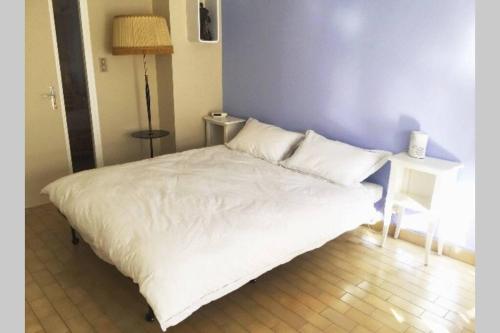 a bed with white sheets and pillows in a room at Les Lavandières in Vernet-les-Bains