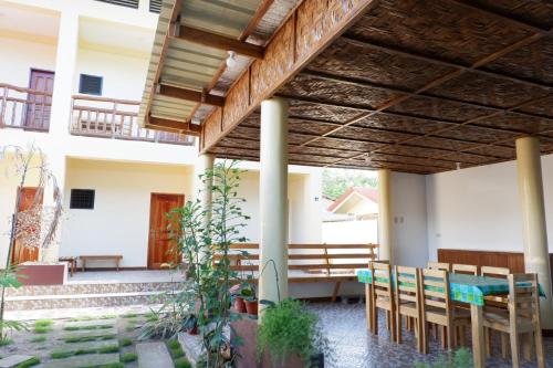a patio with a table and chairs under a pergola at TLShaw Homestay in General Luna