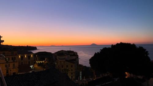 a view of the ocean at sunset from a city at B&B Rivellini in Tropea
