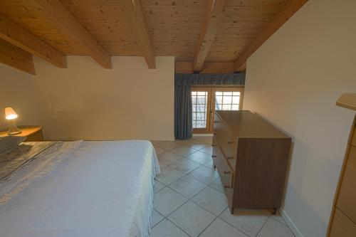a bedroom with a bed and a dresser and a window at B&B Las Vegan in Cles