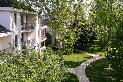 a building with a walkway in front of it at Kenese Bay Garden Resort & Conference in Balatonkenese