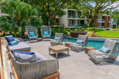 a patio with chairs and a table and a pool at Wyndham Ilhabela Casa Di Sirena in Ilhabela