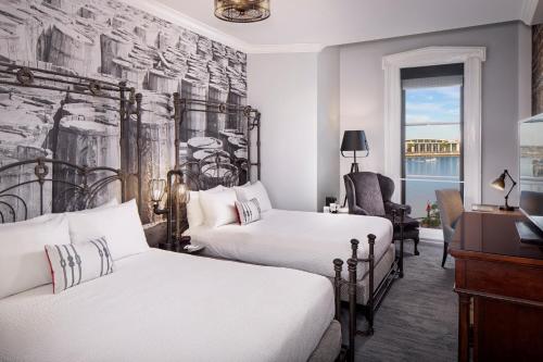 a hotel room with two beds and a chair at River Street Inn in Savannah