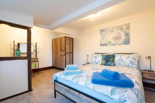 um quarto com uma cama com almofadas azuis em The Brewery lodge em Cirencester