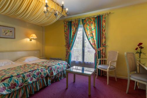 Een bed of bedden in een kamer bij Hôtel Mireille