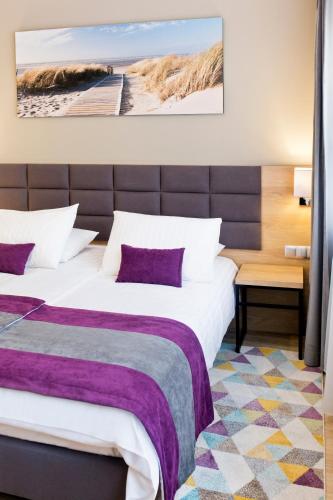 a hotel room with two beds with purple pillows at Hotel CONRAD Comfort in Kraków