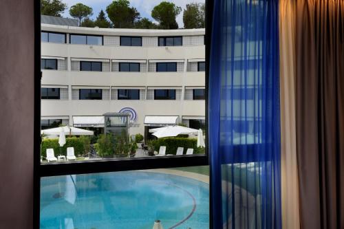a view of a swimming pool from a hotel window at President Park Hotel in Acitrezza