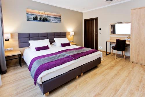 um quarto com uma cama grande e uma secretária em Hotel CONRAD Comfort em Cracóvia
