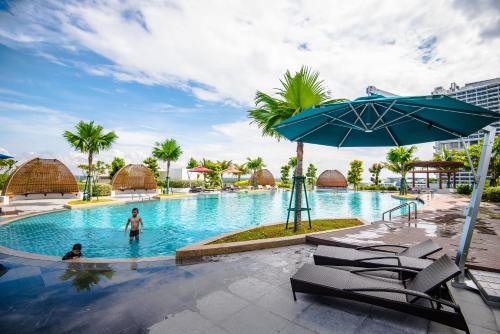 a man in the swimming pool at a resort at Stay @ Almas Puteri Harbour in Nusajaya