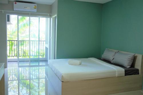 a bedroom with a bed in a room with a window at H12, The Stylish Apartment in Hua Hin