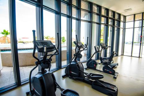 a row of exercise bikes in a gym with windows at Stay @ Almas Puteri Harbour in Nusajaya