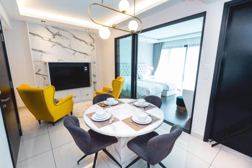 a living room with a dining table and yellow chairs at Stay @ Almas Puteri Harbour in Nusajaya