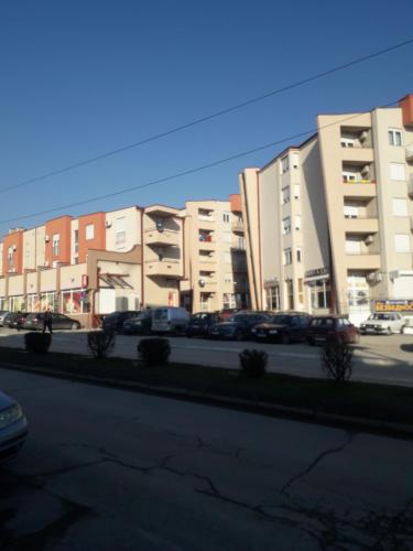 a row of buildings with cars parked in a parking lot at Apartman Katarina in Vranje