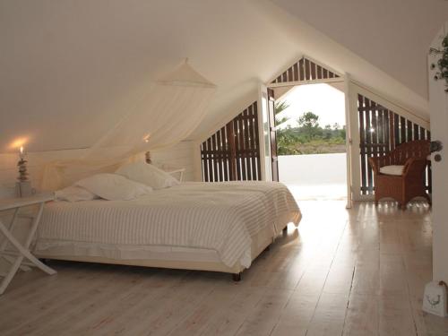 a bedroom with a white bed and a staircase at Villa Oasis Azul - beautiful villa with heated private pool short walk to all amenities in Sesimbra