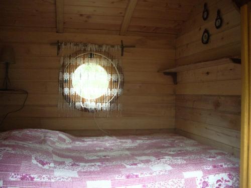 um quarto com uma cama num camarote com uma janela em Roulottes des Trolls em La Boussac