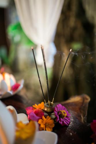 a table topped with colorful flowers and candles at Fox & The Firefly Cottages in Loboc