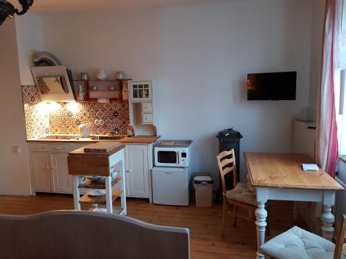 una pequeña cocina con mesa y microondas en Penzion Leticia en Strakonice