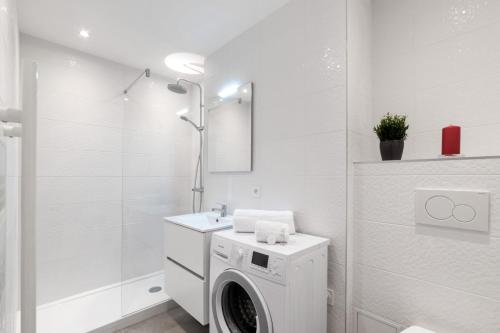 une salle de bain blanche avec une machine à laver à l'intérieur dans l'établissement Appartement Réguillon - Welkeys, à Villeurbanne