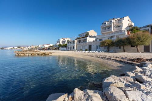 a beach with some buildings and the water at Apartments Antonio - Podstrana, Split in Podstrana