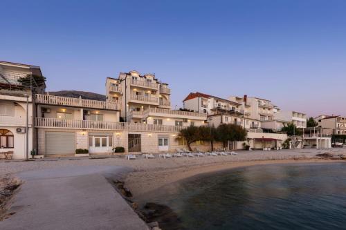 a group of buildings on a beach with a body of water at Apartments Antonio - Podstrana, Split in Podstrana