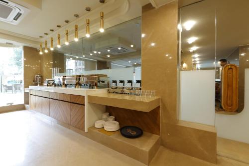 a large kitchen with a counter and a mirror at Artilla Inn in Ahmedabad