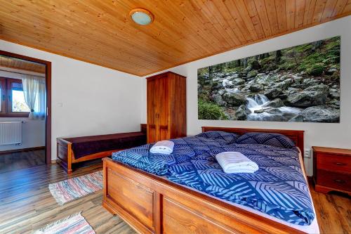 a bedroom with a bed with a painting on the wall at Apartment Lazoň in Pavčina Lehota