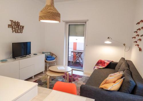 a living room with a couch and a tv at Casas da Avó II in Santa Cruz