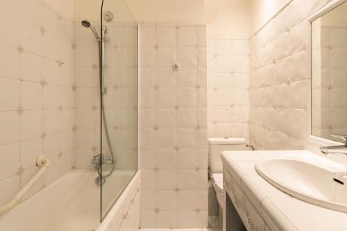 a bathroom with a shower and a sink and a toilet at Hôtel Mireille in Arles