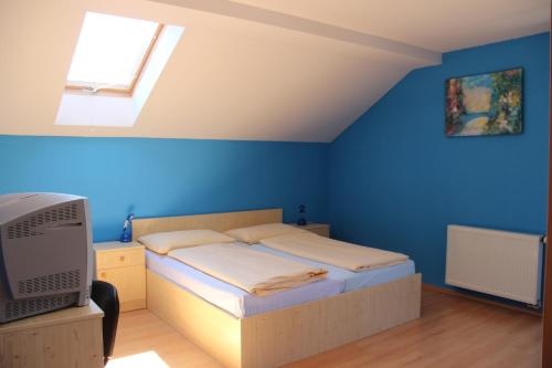 ein Schlafzimmer mit einem Bett und einer blauen Wand in der Unterkunft Villa Park Lipno-Lipno-In in Lipno nad Vltavou